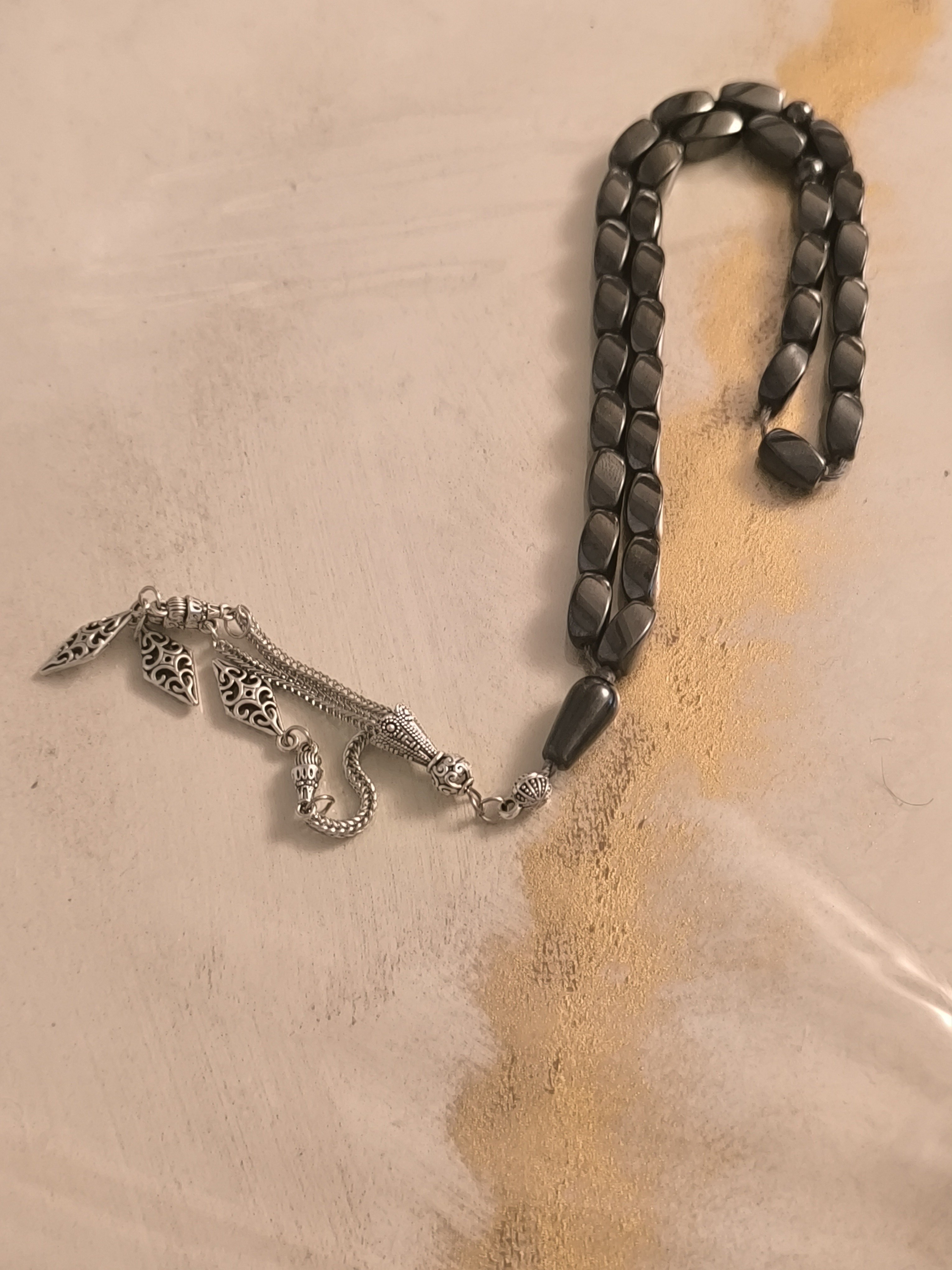 تسبیح ۳۳ دانه سنگ حدید دودی تراش استوانه‌ای با شرابه طرح عثمانی